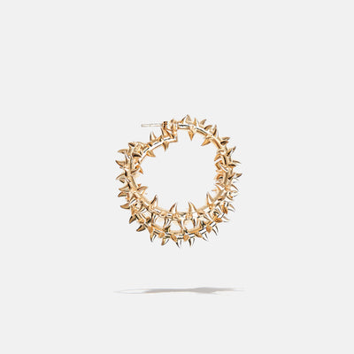 A brass gold fantasy loop earring with spikes, product viewed from the side