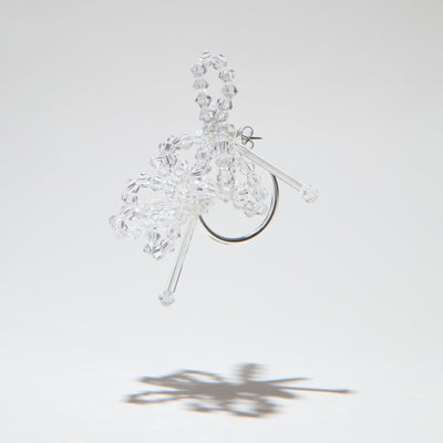 A clear crystal and glass earrings with a half loop closure, displayed against a white background.