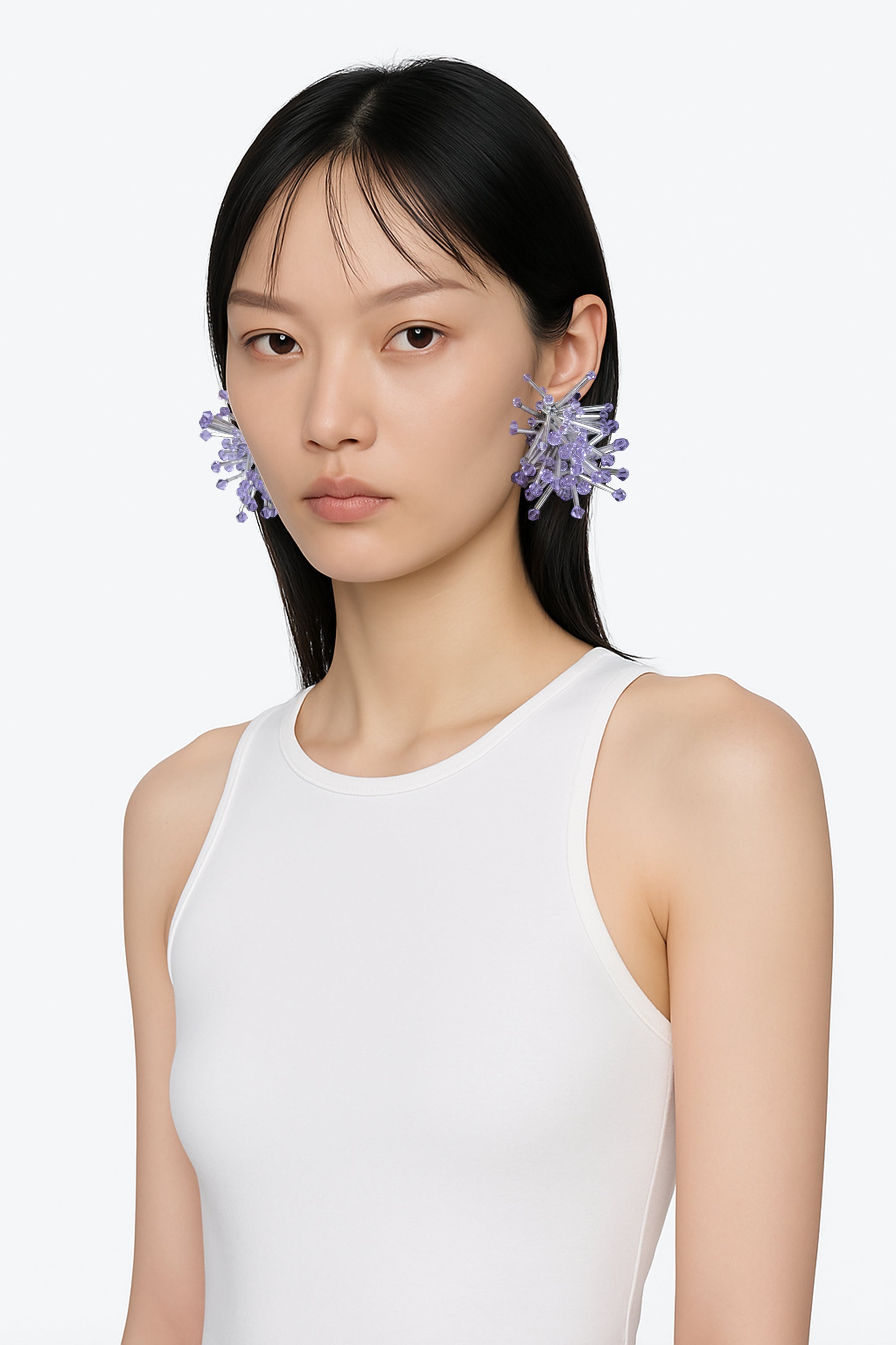 A silver cluster floral sci-fi inspired pair of earrings with purple crystal bicones tips worn by an AI model with white tee and brown hair view from 3/4