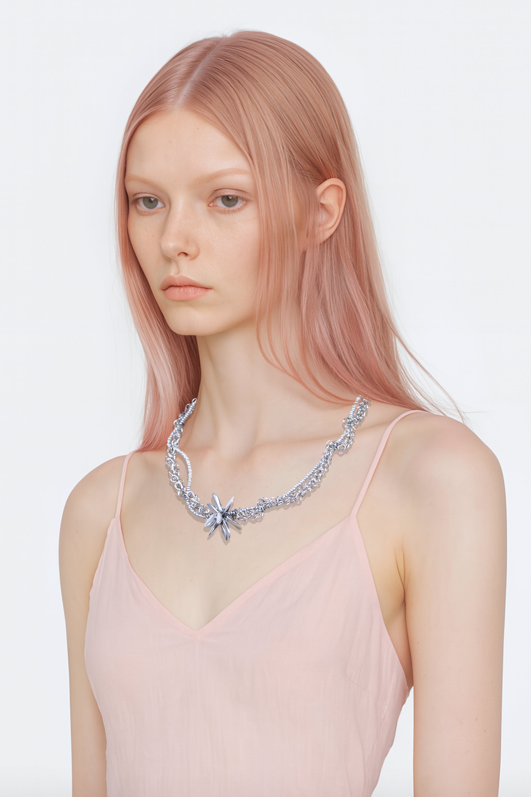Model wearing a silver floral crystal beads tangled chain necklace on a white background