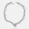 Silver tangled chain beaded necklace with flower pendant on a white background