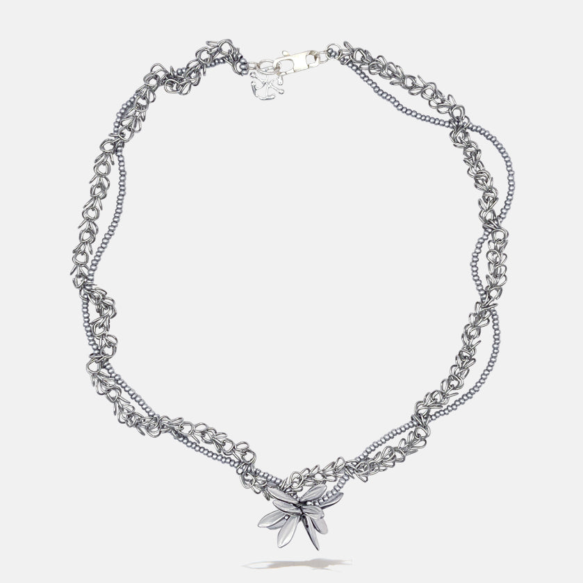 Silver tangled chain beaded necklace with flower pendant on a white background