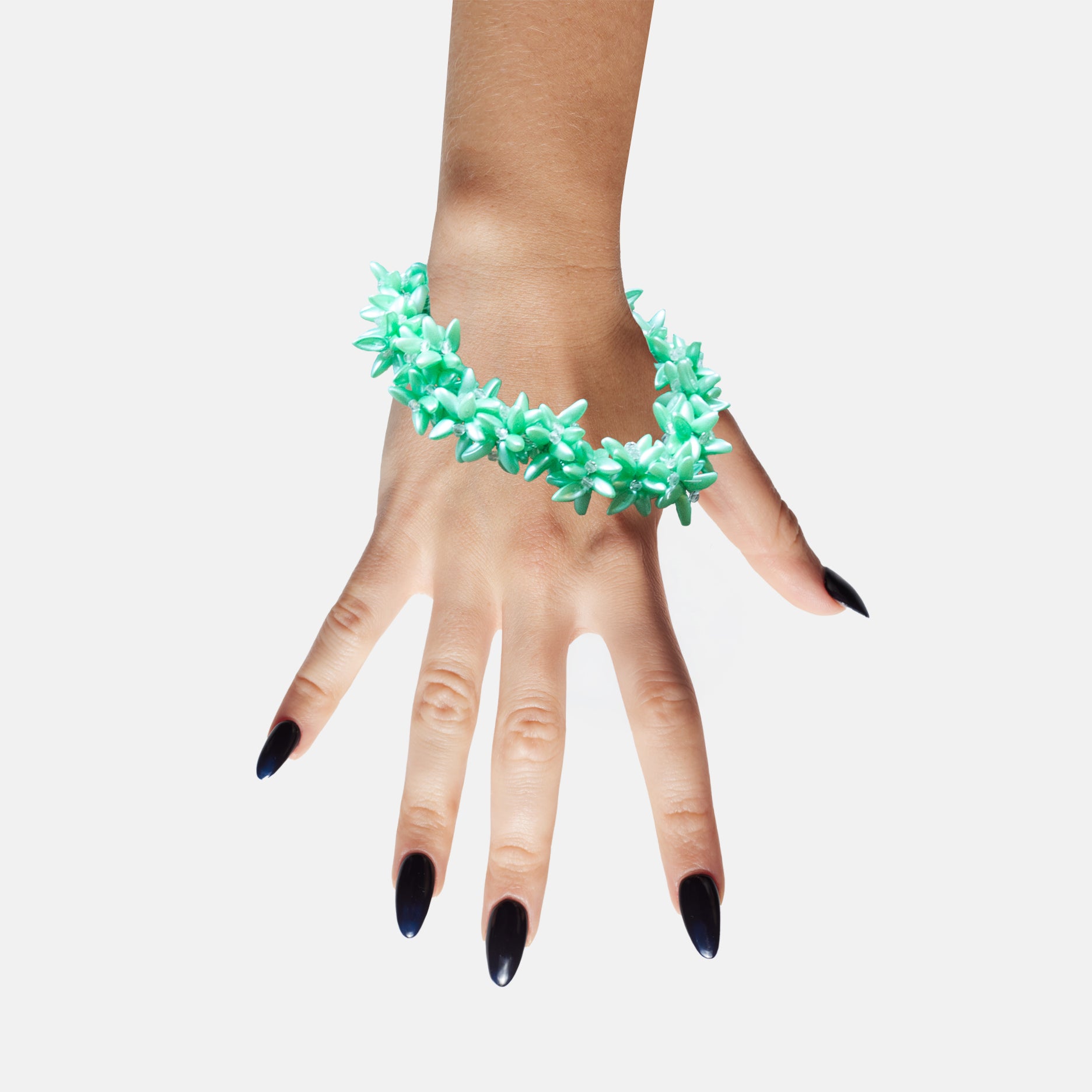Hand Model wearing a green beaded statement bracelet on a white background