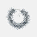 Silver statement bracelet with multi beaded silver flowers on a light gray background