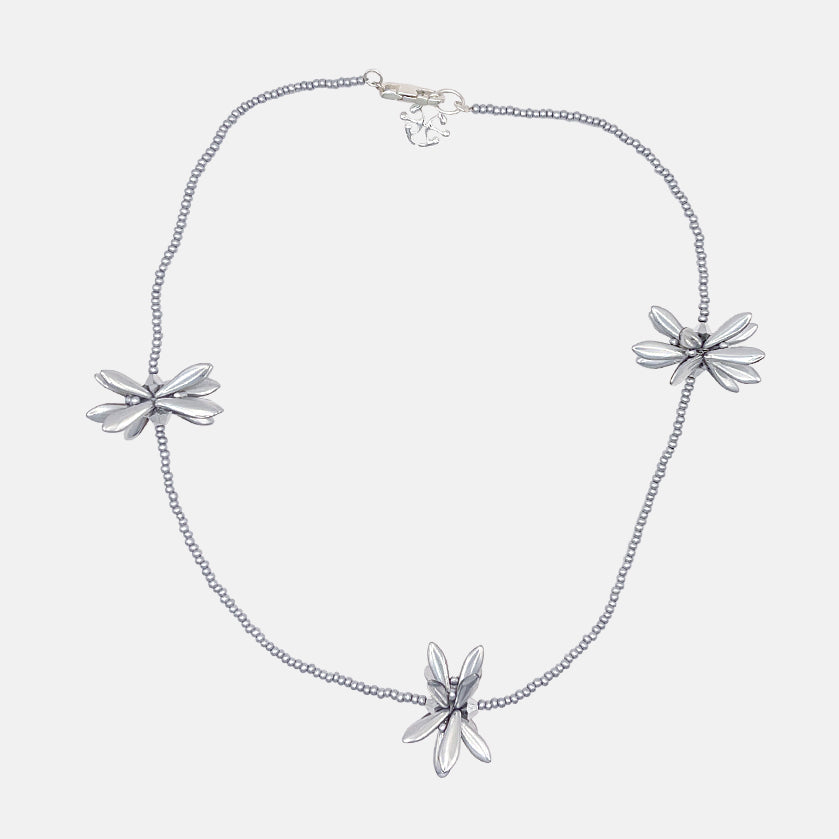 Silver necklace with floral pendants on a white background