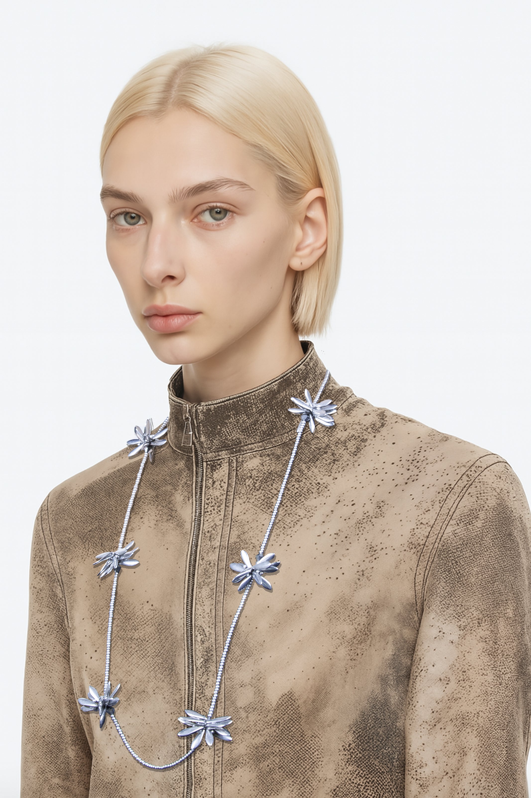 Model wearing a necklace with floral-shaped beaded pendants on a plain background