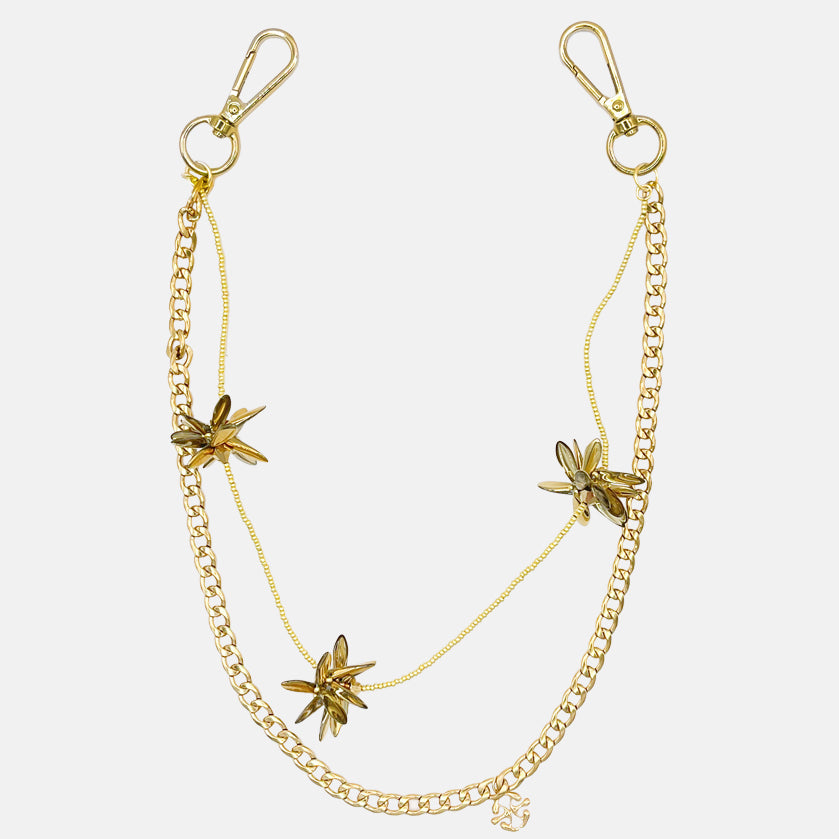 Gold pants chain with floral pendants on a white background