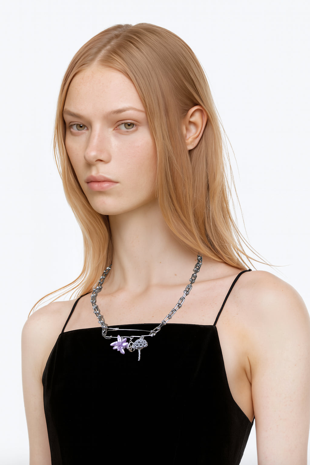 woman wearing a black top with a multi charms chain in stainless steel with an acid purple beaded flower and silver beaded mushroom