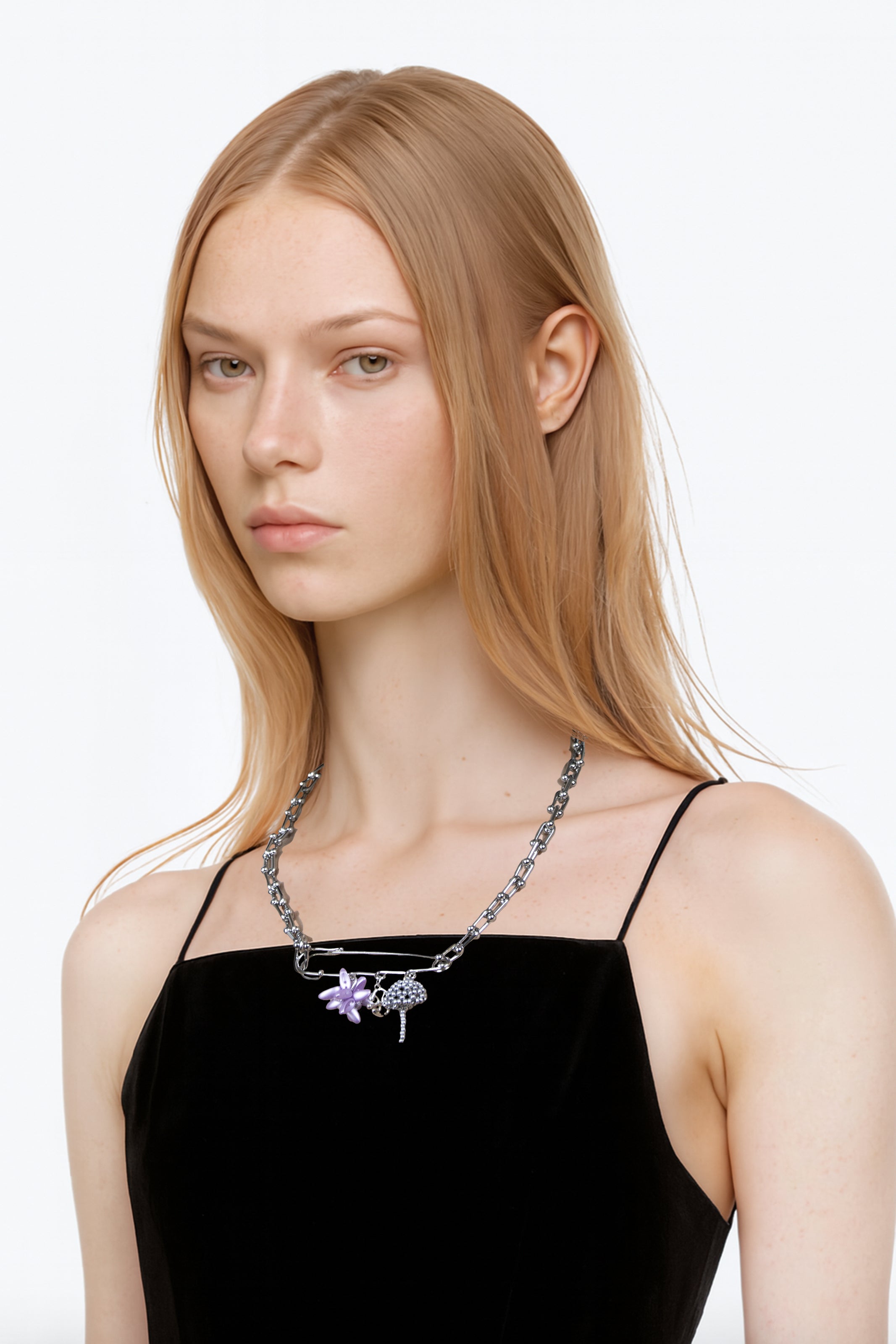 woman wearing a black top with a multi charms chain in stainless steel with an acid purple beaded flower and silver beaded mushroom