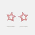 Star-shaped beaded earrings with pink glitter on a light gray background