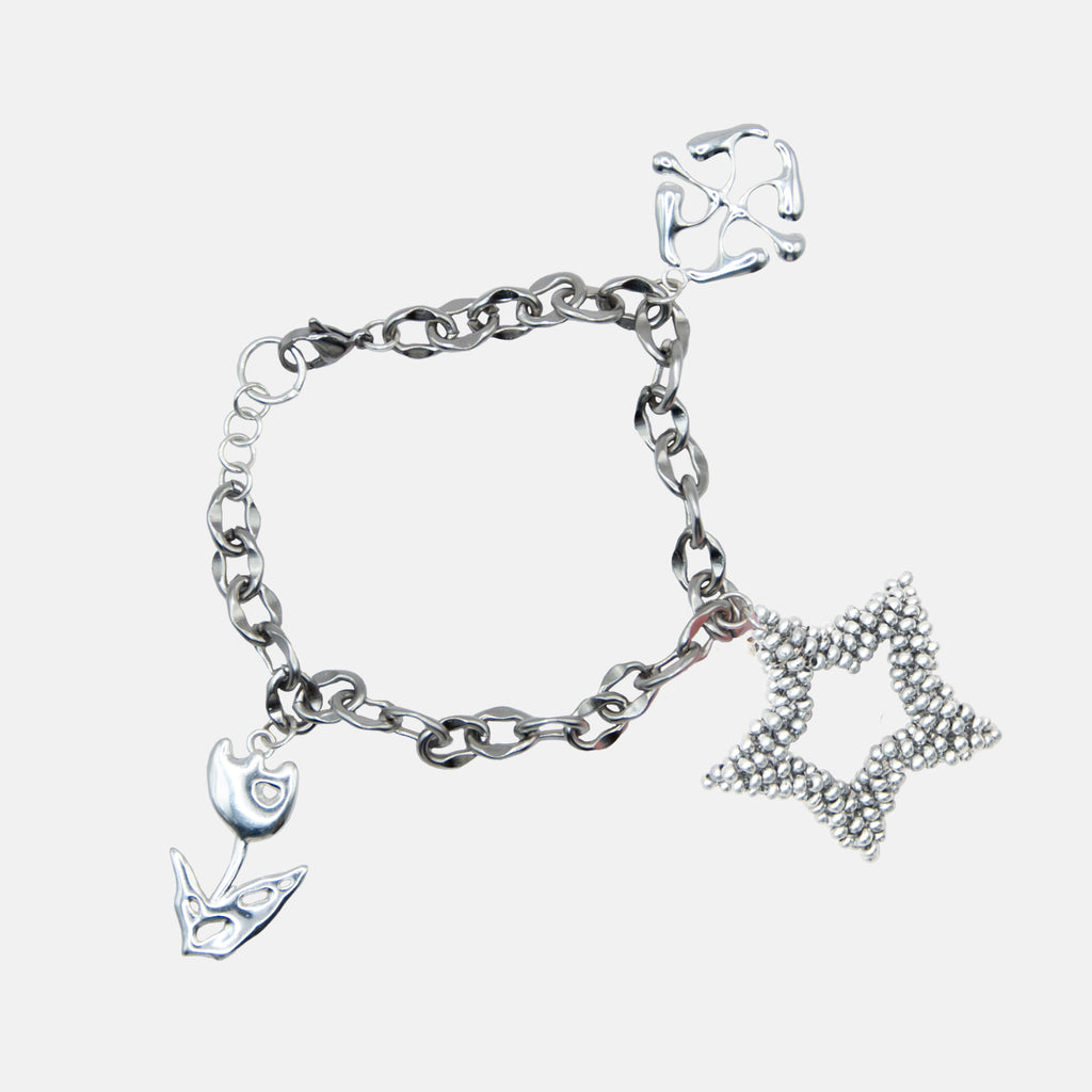 Silver bracelet with various charms on a light gray background