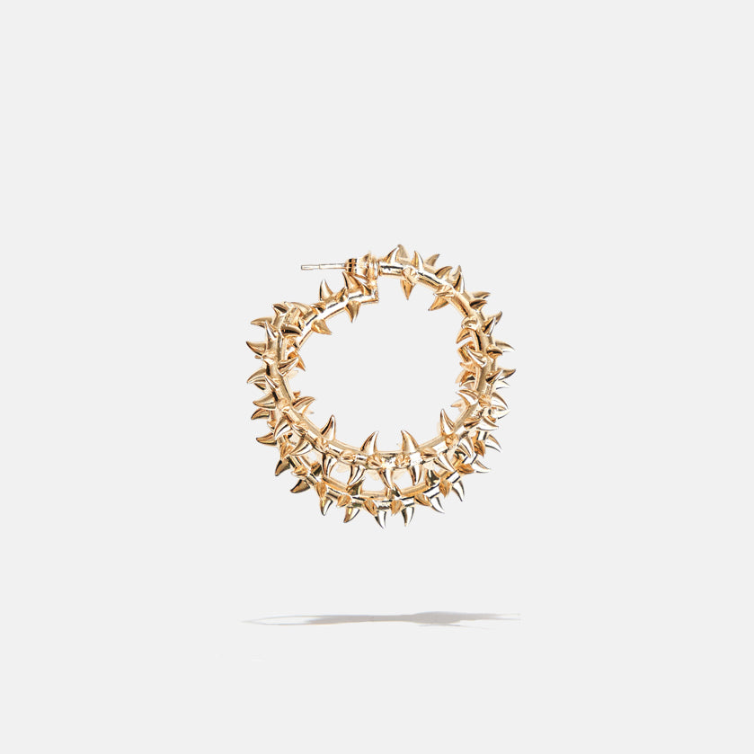 A brass gold fantasy loop earring with spikes,  product viewed from the side