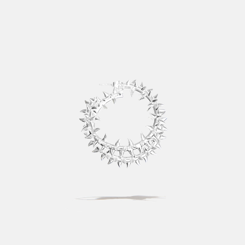 A brass silver fantasy loop earring with spikes, product viewed from the side