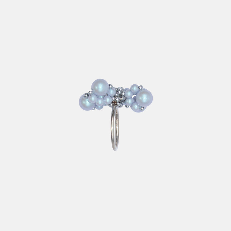 A silver ring with a blue flower design consisting of degenerative petals and a heart shape.