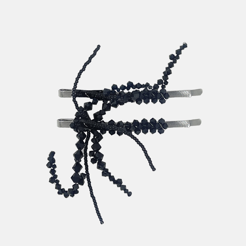 Black beaded hair pins on a white background